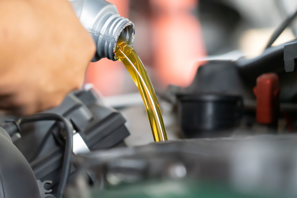 Nahaufnahme des Öl, das in den Tank gefüllt wird in der Motorhaube